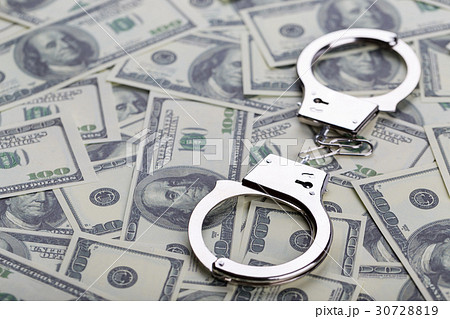 Pair of handcuffs closeup on dollar banknotes 30728819