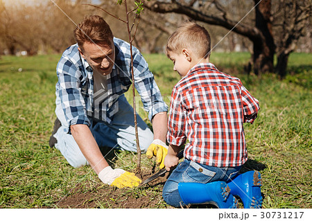Little kid and his father gardening together 30731217