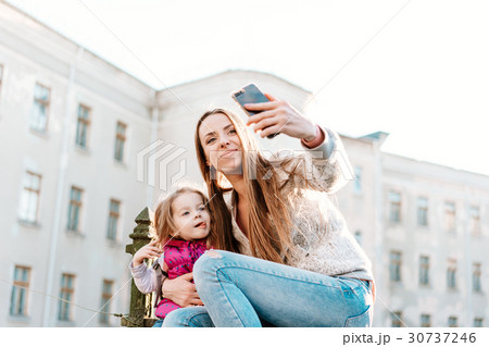 Mom and daughter sit together on the fence Mom and daughter sit together on the fence 30737246