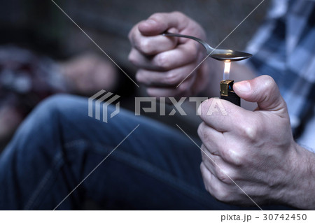 Experienced freak heating heroin on the spoon in Experienced freak heating heroin on the spoon in 30742450