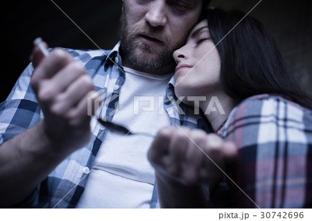 Tired obsessed couple preparing heroin dose Tired obsessed couple preparing heroin dose 30742696