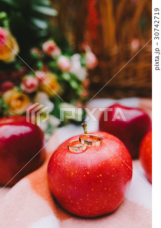Candle surrounded by red rose petals  30742719