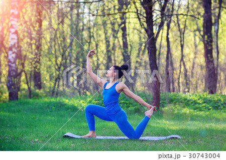Young woman doing yoga exercises in the summer Young woman doing yoga exercises in the summer 30743004