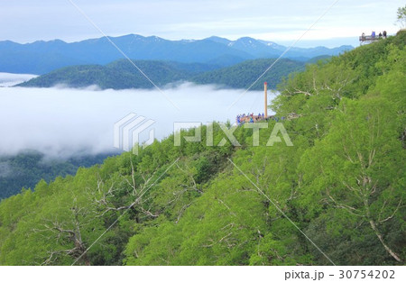 北海道占冠村トマムの山間部に発生した雲海越しに日高山脈の絶景を展望台から見る観光客 30754202