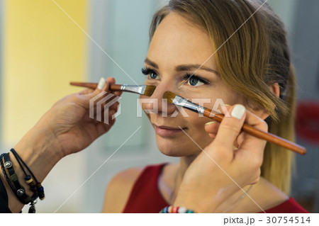 Make-up artist doing makeup to beautiful young Make-up artist doing makeup to beautiful young 30754514
