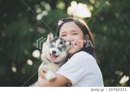 asian girl playing with siberian husky puppy 30760331