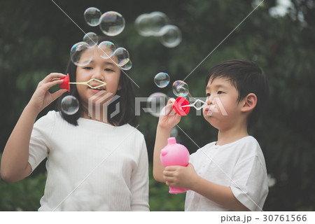 asian children is blowing a soap 30761566