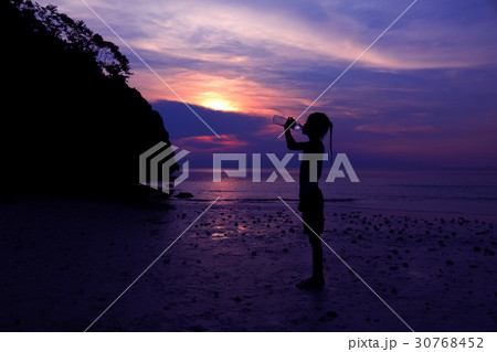 Asian girl drinking water on the beach. Asian girl drinking water on the beach. 30768452