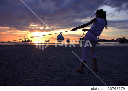 Asian girl pulling rope on the beach. Asian girl pulling rope on the beach. 30768579
