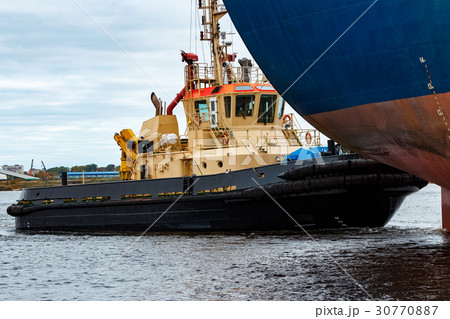 Tug ship towing blue bulk carrier Tug ship towing blue bulk carrier 30770887