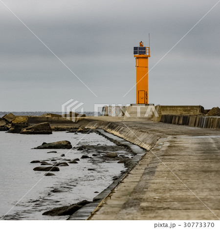 Breakwater dam with yellow lighthouse 30773370