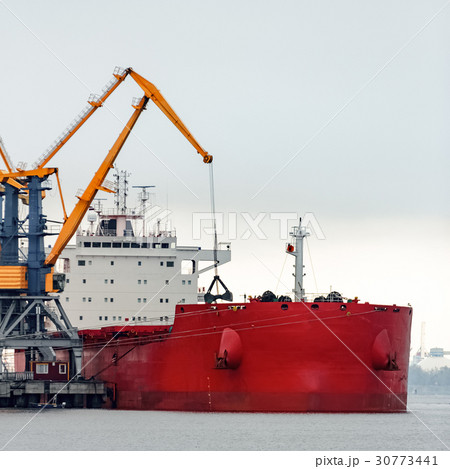Large red cargo ship loading 30773441