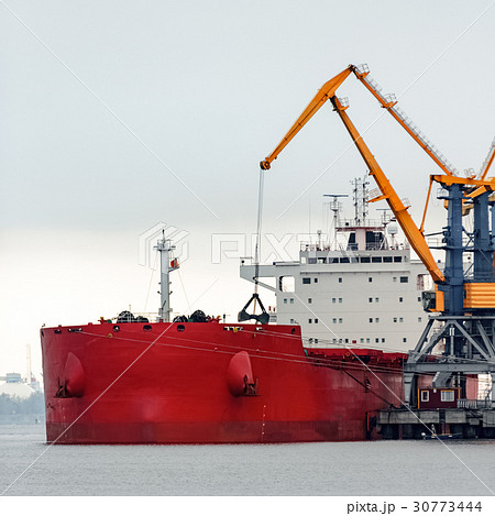 Large red cargo ship loading 30773444