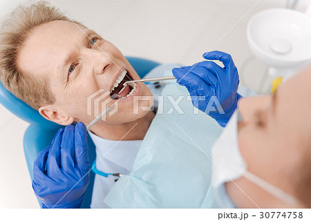 Attentive scrupulous dentist observing every 30774758