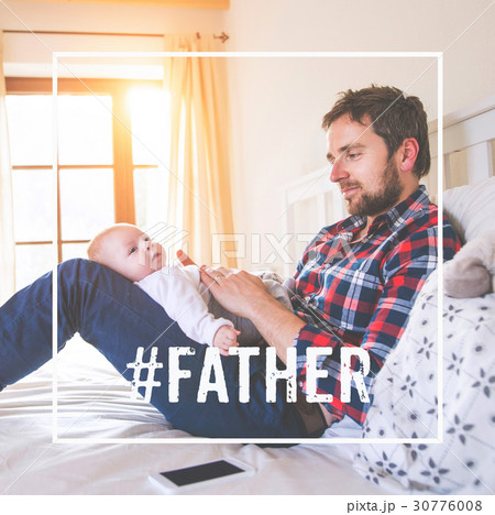 Father sitting on bed holding baby son. Fathers 30776008
