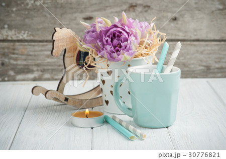 pink tulips, blue cup, straws, lit candle  30776821