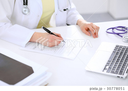 Close-up of a female doctor filling  ou 30778051