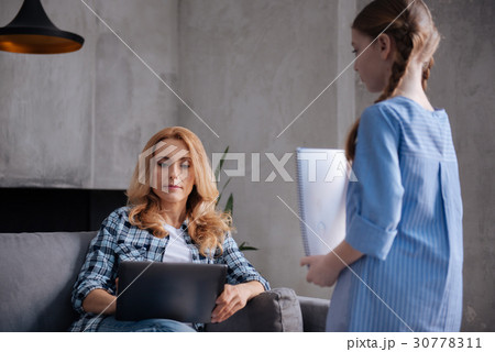 Charming kid demonstrating picture to the busy 30778311