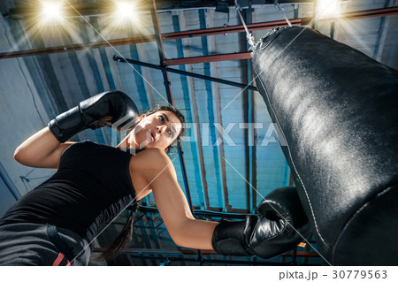 The female boxer training at gym 30779563