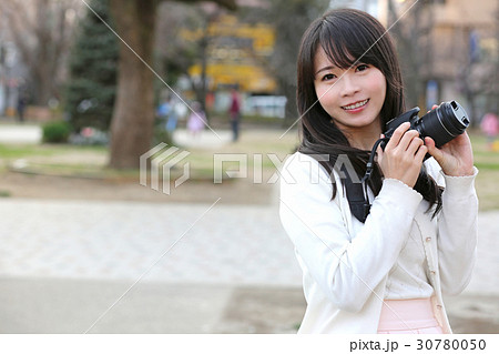 カメラを持ち笑顔の女性 30780050
