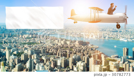 Biplane with businessman and blank banner 30782773