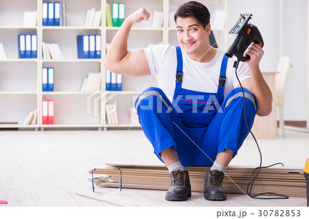 Young worker working on floor laminate tiles 30782853