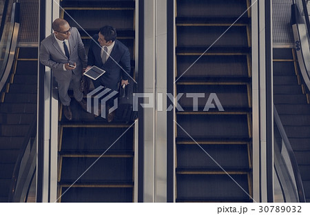 Business Men Talk Tablet Escalator 30789032