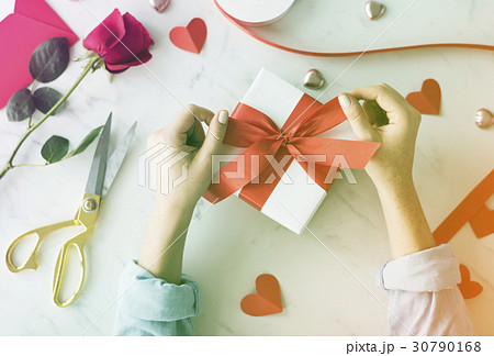 Hands tie ribbon on gift box Hands tie ribbon on gift box 30790168