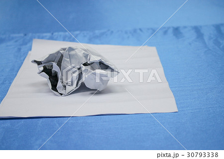Crumpled paper lump on blue table background Crumpled paper lump on blue table background 30793338