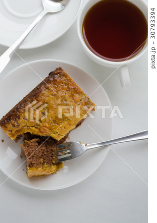 Caramel Peanut-Topped Brownie Cake and Cup of Tea. 30793394