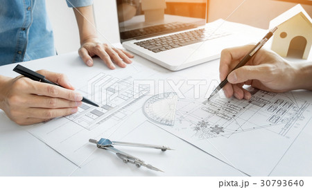 Architects engineer discussing at the table with blueprint - Clo 30793640
