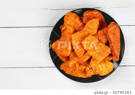 homemade chicken nuggets on black plate 30795261