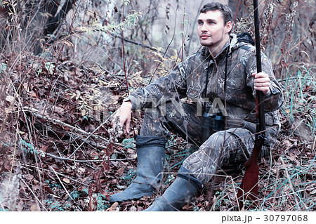 A man in camouflage and with a hunting rifle 30797068