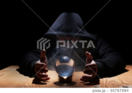 man in a black hood with cristal ball 30797084