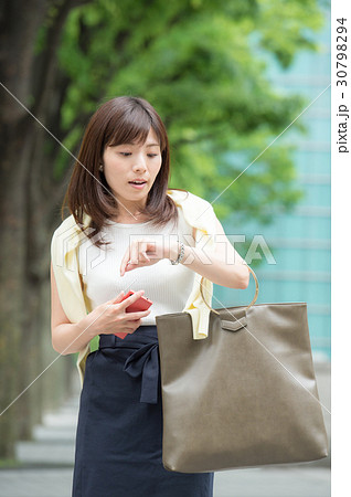 腕時計を見る若い女性の写真素材