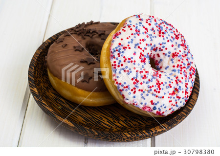 Delicious donuts on white wooden background 30798380