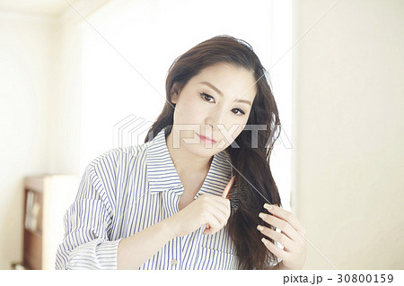 lady is brushing her long hair in the morning 30800159