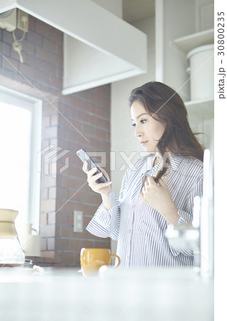 attractive asian woman using smartphone in kitchen 30800235