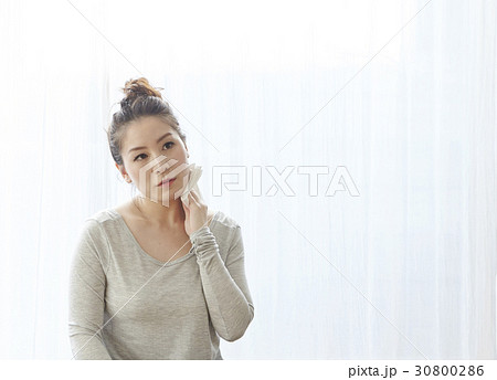 A woman is cleaning sweat after doing yoga exercise. A woman is cleaning sweat after doing yoga exercise. 30800286