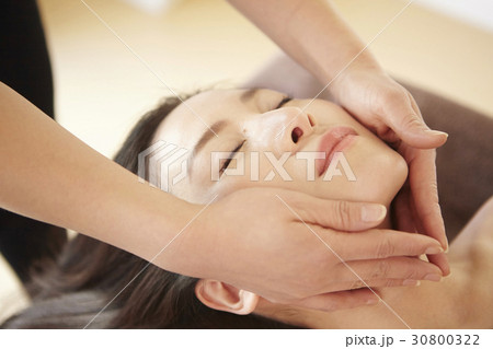 A young woman gets a facial massage in spa. A young woman gets a facial massage in spa. 30800322