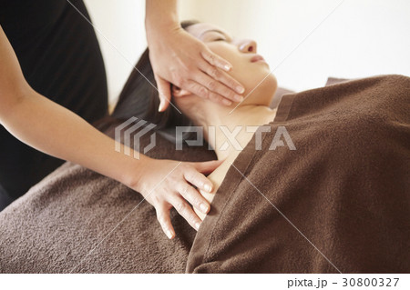 the therapist is massaging neck and shoulder. 30800327
