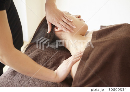 the therapist is massaging neck and shoulder. 30800334