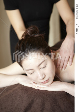 A woman is getting a shoulder massage in spa. 30800348