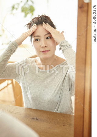 The woman is touching her face and enjoying her clean skin. 30800376