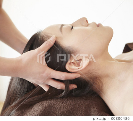 a woman gets facial and hair massage in spa 30800486