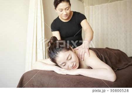 a woman enjoys a body massage in a room of spa. 30800528