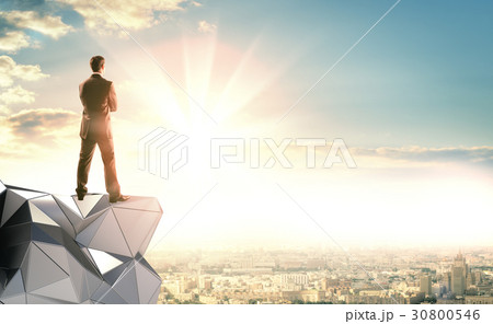 A businessman stands on an abstract construction A businessman stands on an abstract construction 30800546