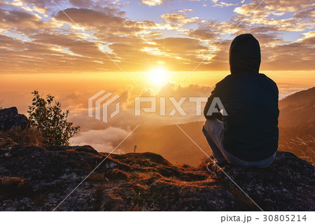 Lonely Man sitting on a mountain for watching  30805214