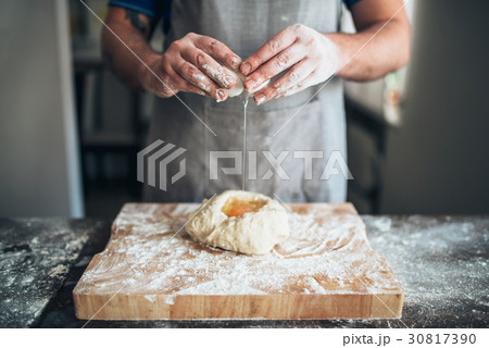 Chef hands mix dough with egg, bread preparation 30817390