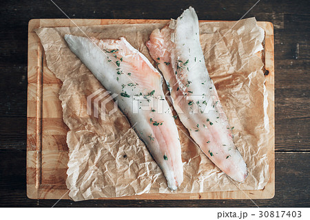 Raw fish slices with spices on cutting board Raw fish slices with spices on cutting board 30817403